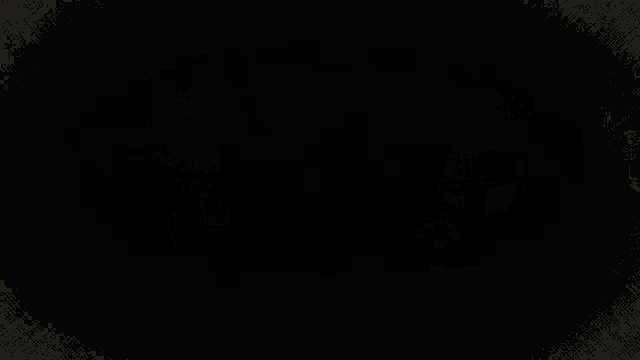 a silhouette of a person in a black cape against a dark cloudy sky