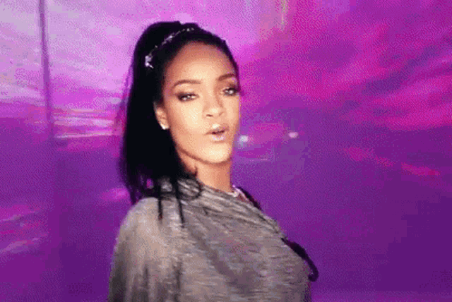 a woman is standing in front of a purple background .