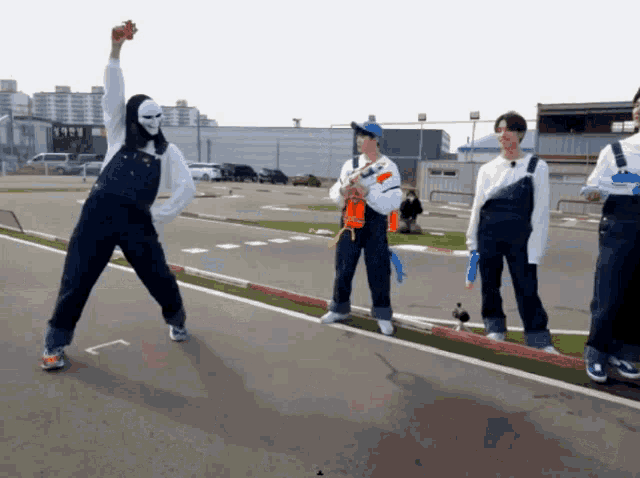 a man wearing overalls and a mask is standing on a track