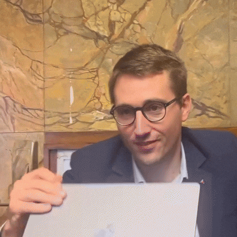 a man wearing glasses is holding a laptop