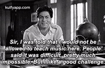 a man is sitting at a table in a black and white photo with a quote .