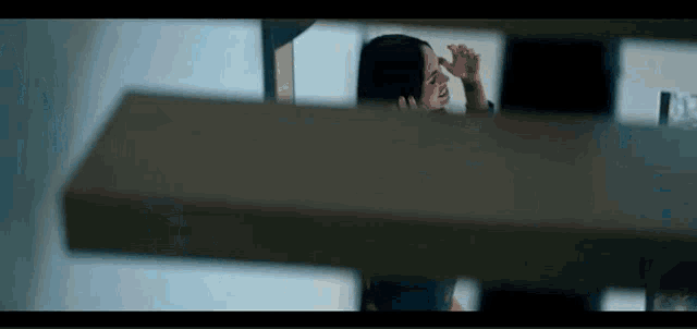 a woman is looking at herself in a mirror and touching her nose .