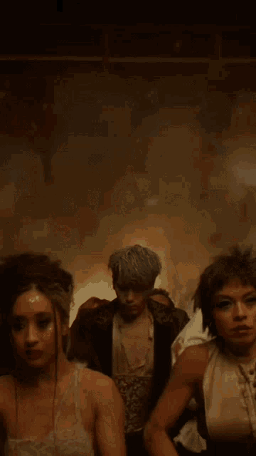 a man in a corset is surrounded by people with their hands in the air