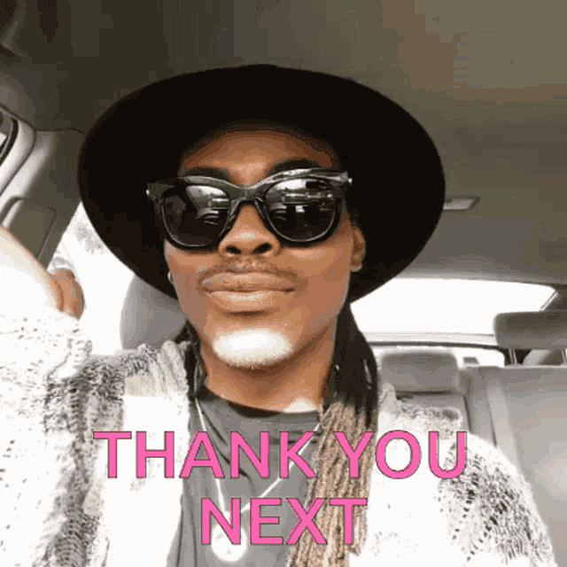 a man wearing sunglasses and a hat is sitting in a car with the words thank you next below him