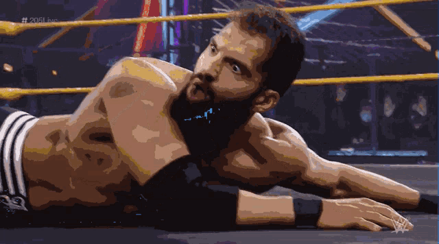 a pixel art of a man laying on the ground in a wrestling ring with the words # 2021 live on the bottom