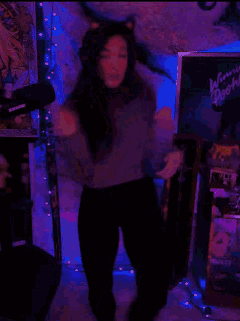 a woman dancing in front of a sign that says winnie the pooh