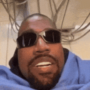 kanye west is wearing sunglasses and a blue shirt .