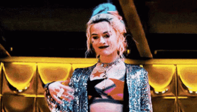 a woman is standing in a room wearing a sequined jacket and a bra .