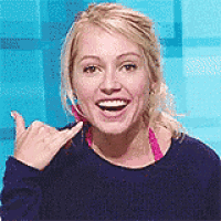 a woman in a blue shirt is smiling and giving a thumbs up sign