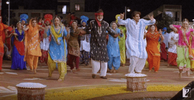 a group of people are dancing in front of a sign that says ' india ' on it