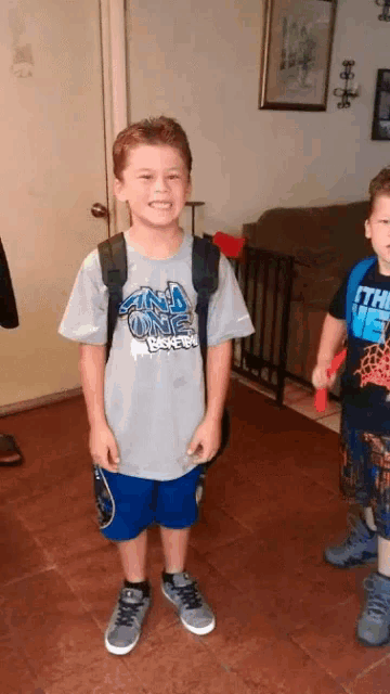 a boy wearing a gray shirt that says oklahoma magic basketball