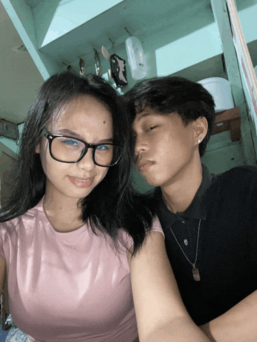 a boy and a girl are posing for a picture and the girl has blue eyes