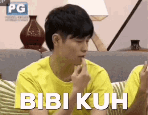 a man in a yellow shirt is sitting on a couch with his finger on his lips and the words bibi kuh above him