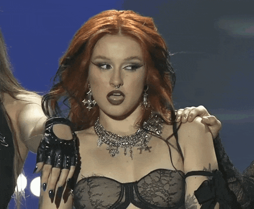 a woman with red hair is wearing a necklace with a star on it