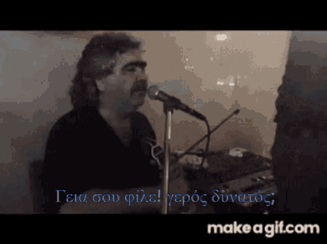 a man singing into a microphone with the words make a gif.com written below him