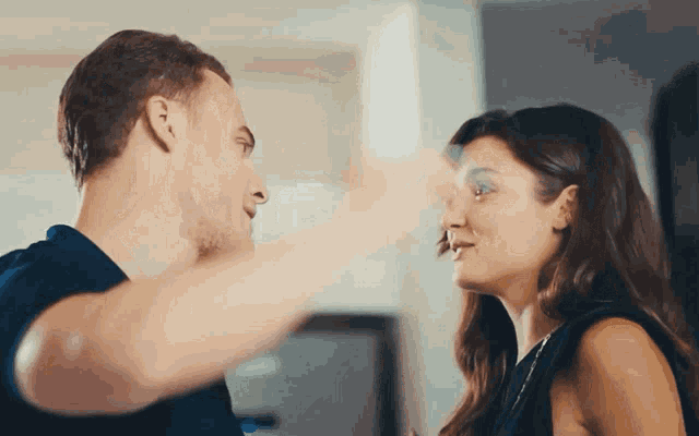 a man and a woman are touching their foreheads and looking at each other