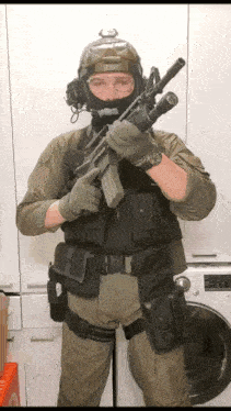 a man in a military uniform holds a rifle in front of a washing machine