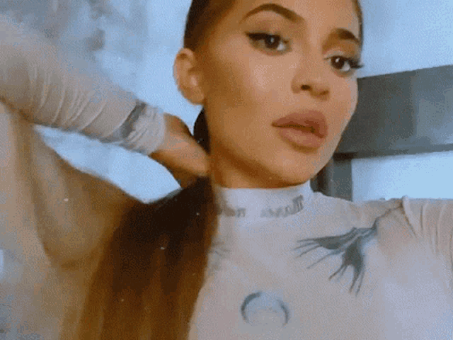 a close up of a woman 's face with her hair in a ponytail .