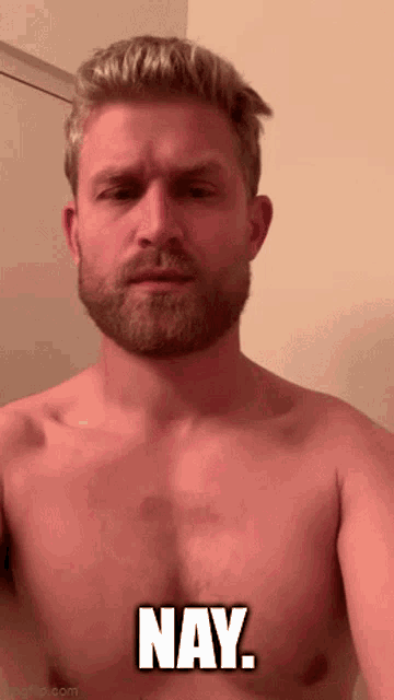 a shirtless man with a beard is making a face and saying nay