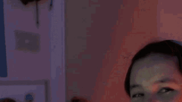 a young girl wearing headphones is smiling and making a funny face .