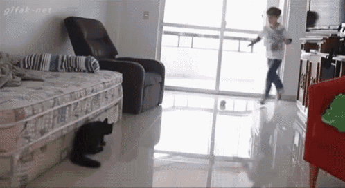 a boy is walking through a living room with a sliding glass door