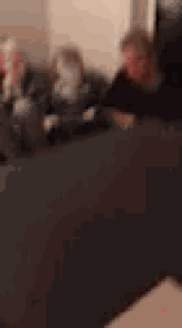 a blurry picture of a man in a black shirt sitting down .