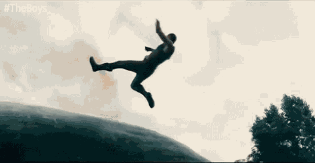 a man is jumping in the air while wearing a superhero costume .
