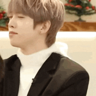 a close up of a man wearing a suit and a white turtleneck .