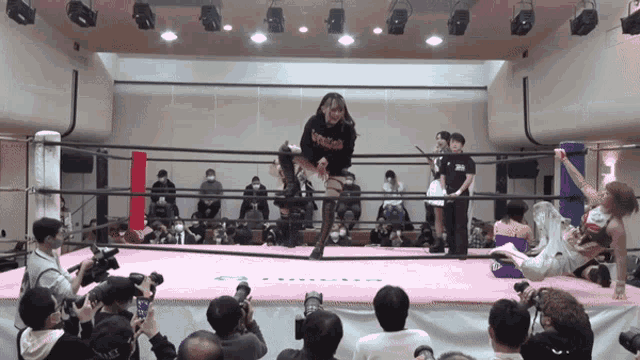 a woman in a wrestling ring is wearing a black shirt that says ' assault ' on it