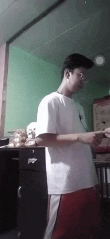 a young man wearing headphones and a white t-shirt is standing in a room .