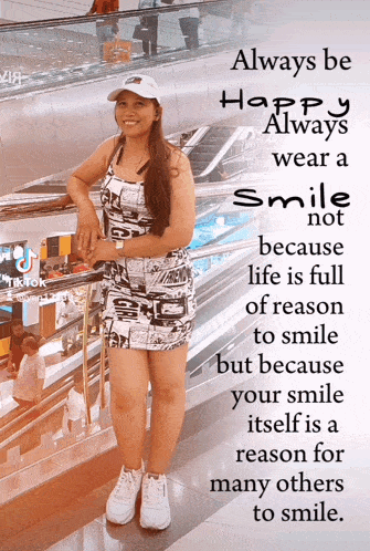 a woman stands in front of a sign that says always be happy