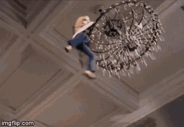 a person is hanging from a chandelier with their legs hanging out .