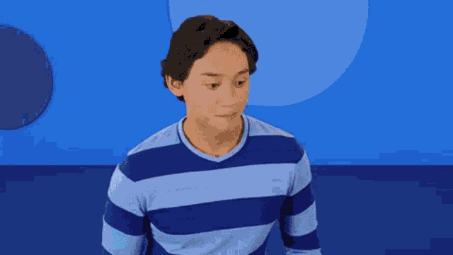 a man in a blue striped shirt is making a surprised face .