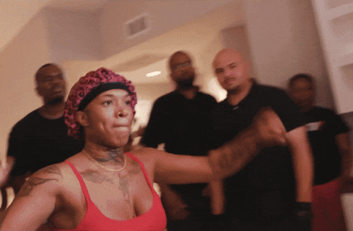 a woman with a tattoo on her arm stands in front of a group of people