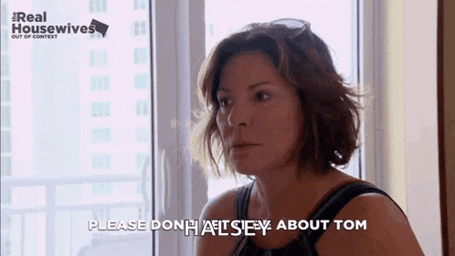 a woman is sitting in front of a window and saying please don 't hate me about tom