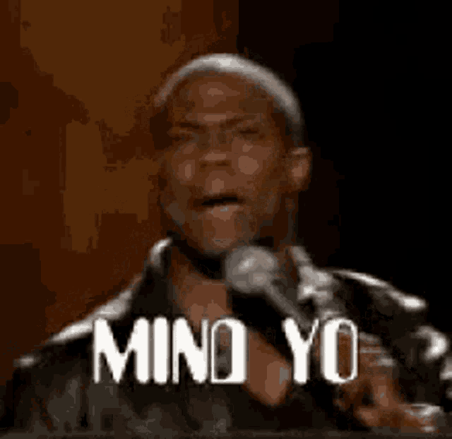 a man is giving a speech in front of a microphone and says mind yo