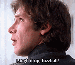 a close up of a man 's face with the words `` laugh it up , fuzzball '' written on it .