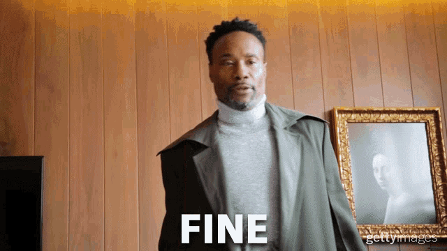 a man standing in front of a framed picture with the word fine written on it