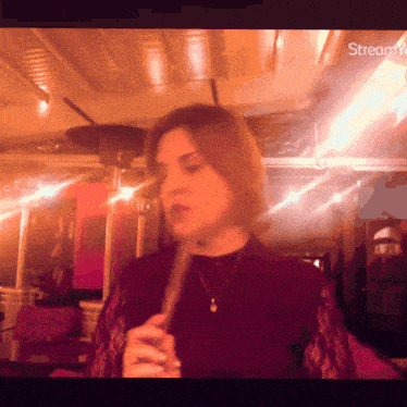 a woman playing a flute in a dark room with the words stream on the bottom