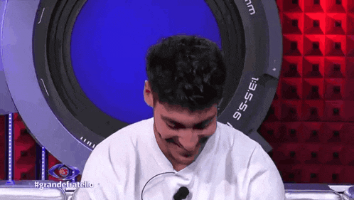 a man with a microphone in front of a camera lens that has the number 135 on it