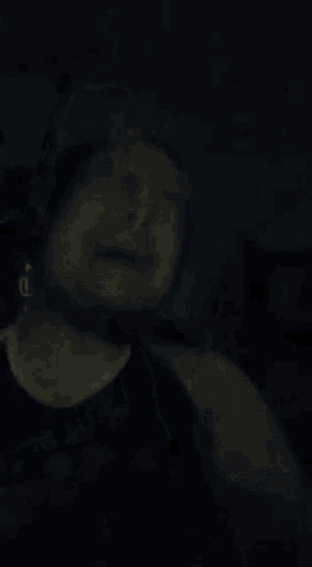 a man is holding his chest in the dark .