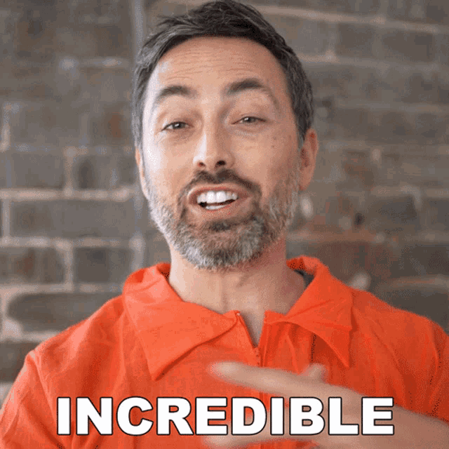 a man wearing an orange shirt with the word incredible written on it