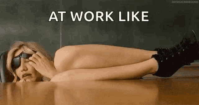 a naked woman is laying on a table with her legs crossed and sunglasses on .