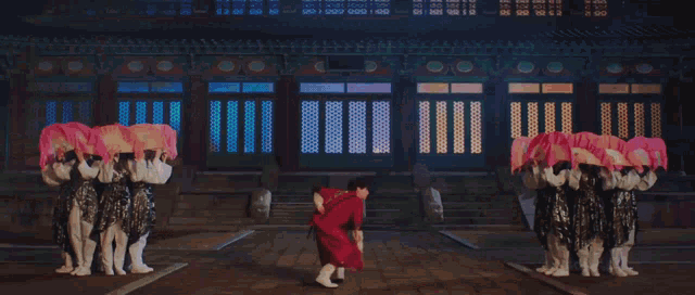 a group of people in traditional korean costumes are holding pink fans