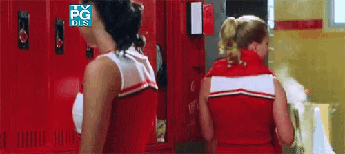 two cheerleaders are standing in front of red lockers with a tv pg dls logo on the top