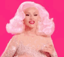 a woman with white hair and pink lips is wearing a white dress and dancing on a pink background .