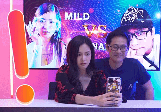 a man and a woman are taking a selfie in front of a screen that says " mild vs "