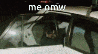 a man is sitting in a police car with the words me omw on the bottom