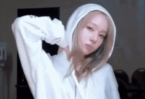 a woman wearing a white hoodie with a hood on her head