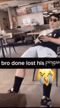 a man is sitting in a restaurant with a caption that says bro done lost his pinga 's